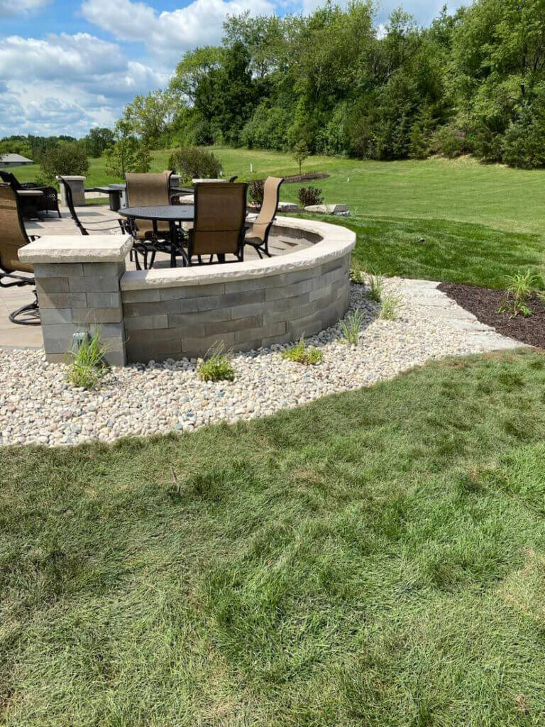 Patio in backyard with grass and verdant landscape